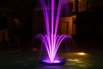 Illuminated fountain at night