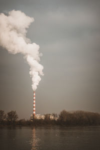 Smoke emitting from chimney against sky