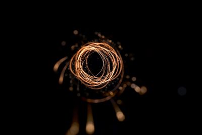 Close-up of illuminated lighting equipment against black background