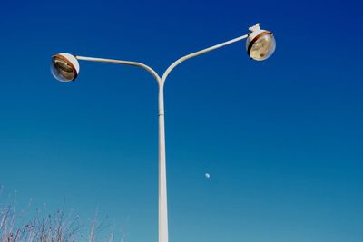 Low angle view of street light against clear blue sky