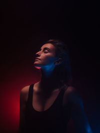 Young woman with eyes closed in darkroom