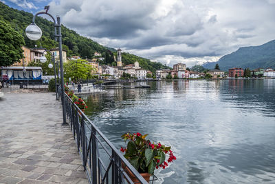 Scenic view of lake by buildings in town against sky