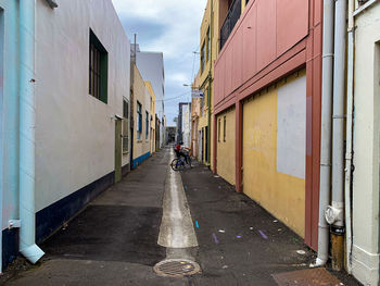 Cyclist riding down the backstreets of napier amidst buildings in city