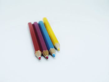 High angle view of multi colored pencils against white background