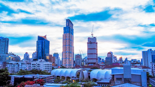 Buildings in city against cloudy sky