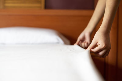 Close-up of woman hand on bed at home