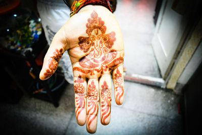 Cropped image of woman with henna tattoo at home