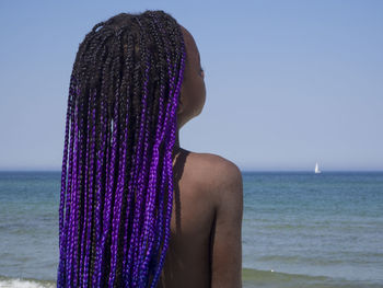 Girl with braided hair against sea