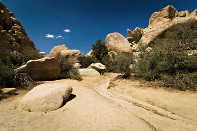 Rock formations on landscape against blue sky