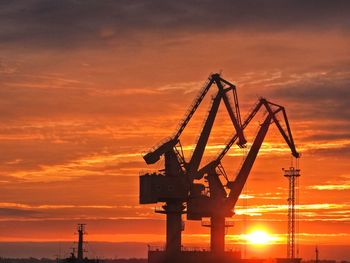 Silhouette crane against sky during sunset