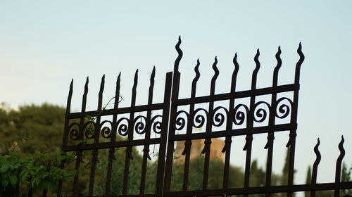 Close-up of fence on field against sky