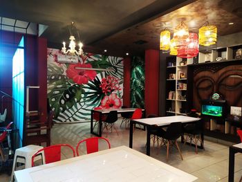 Empty chairs and tables in illuminated restaurant