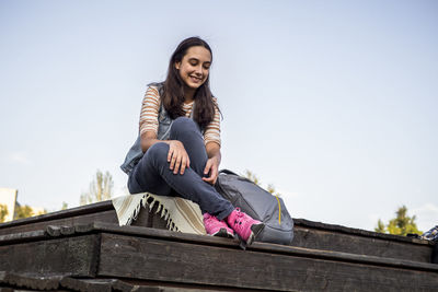 Low angle view of young woman standing on roof