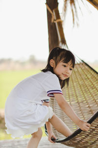 Side view of girl holding hammock