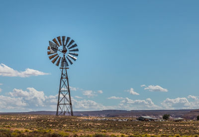 Windmill on field against sky