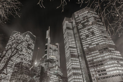 Low angle view of illuminated buildings against sky at night