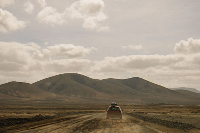 Scenic view of country road on field against sky