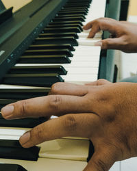Midsection of person playing piano