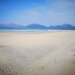 Scenic view of beach against blue sky