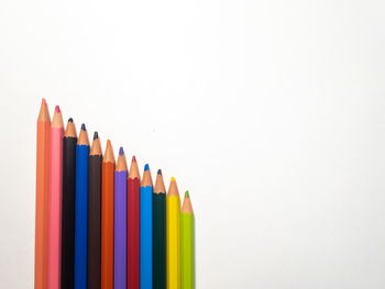 Close-up of colored pencils against white background