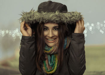 Smiling girl with cold and with a hood and a scarf