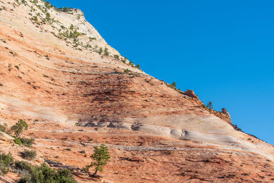 Low angle landscape of orange stone hillside at checkerboard mesa in zion national park