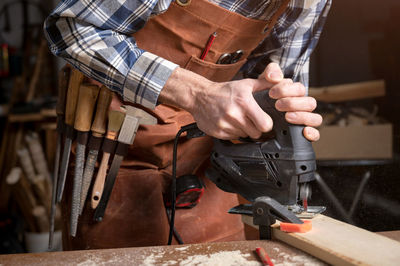 Midsection of man working in workshop