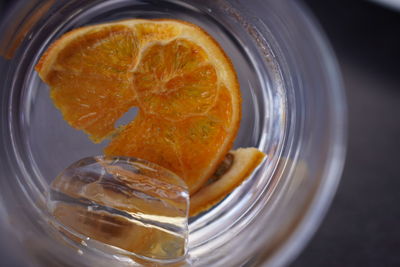 Close-up of orange and ice cube remaining in empty cocktail glass 