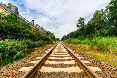 Railroad tracks amidst trees against sky
