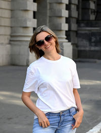 Portrait of young woman standing on street