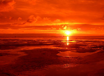 Scenic view of sea against dramatic sky during sunset