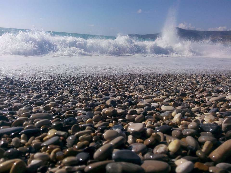 sea, water, beach, pebble, stone - object, shore, nature, scenics, beauty in nature, rock - object, sky, horizon over water, surface level, tranquility, wave, tranquil scene, sunlight, sand, surf, motion