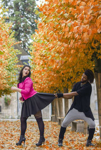 Woman standing by tree during autumn