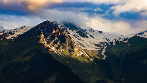 Mountain landscape in evening.
golden sun light falling on mountain peak in the evening,snow
