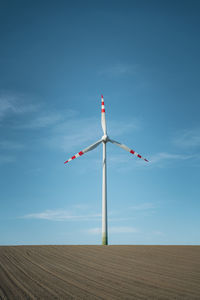 Windmill on field against sky