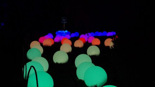 Low angle view of multi colored lights against black background