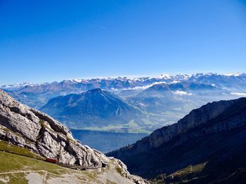 Scenic view of snowcapped mountains against clear blue sky