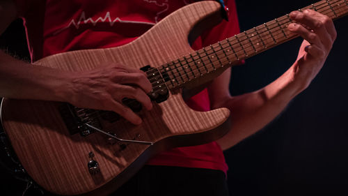 Midsection of man playing guitar