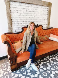 Portrait of woman sitting on sofa at home