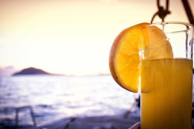 Close-up of drink against sea and sky