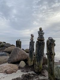 Stack of rocks by sea against sky