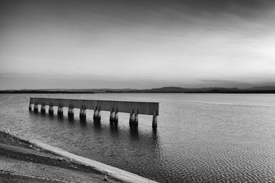 Pier on lake against sky