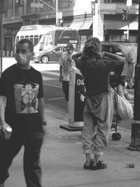 Rear view of people standing on street in city