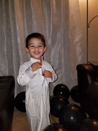 Portrait of smiling boy in traditional clothing sitting at home