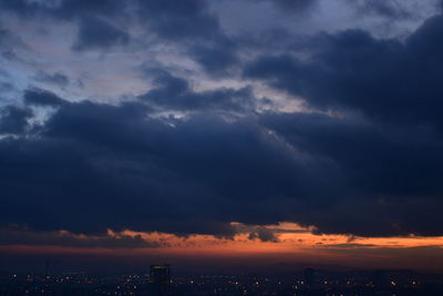 Scenic view of city against sky at sunset