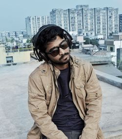 Young man wearing sunglasses while standing in city