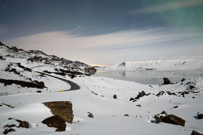 Scenic view of snow covered mountains against sky at night