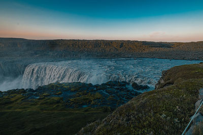 Scenic view of waterfall against sky