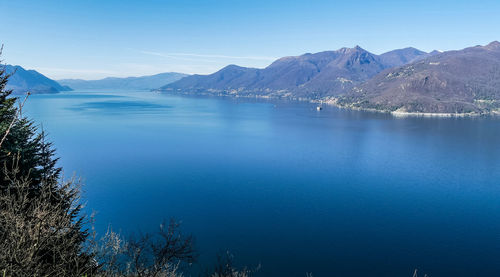 Scenic view of lake and mountains against blue sky