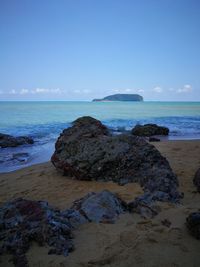 Scenic view of rocks on beach against sky